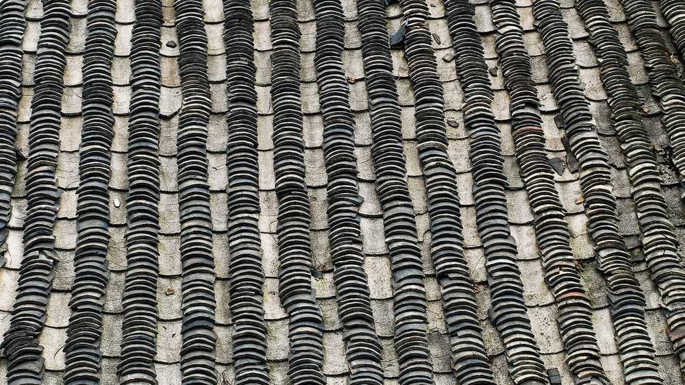 Toit en ardoise d'une maison ancienne du Pays basque, pente forte et rives maçonnées